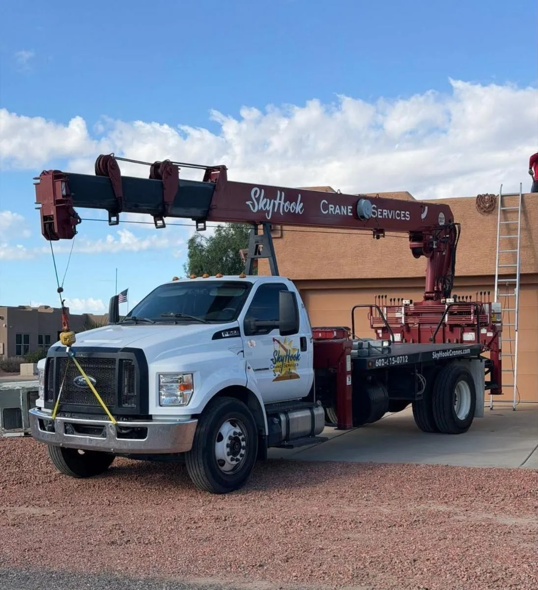 Skyhook Crane boom truck positioned beside a commercial roof for a lift